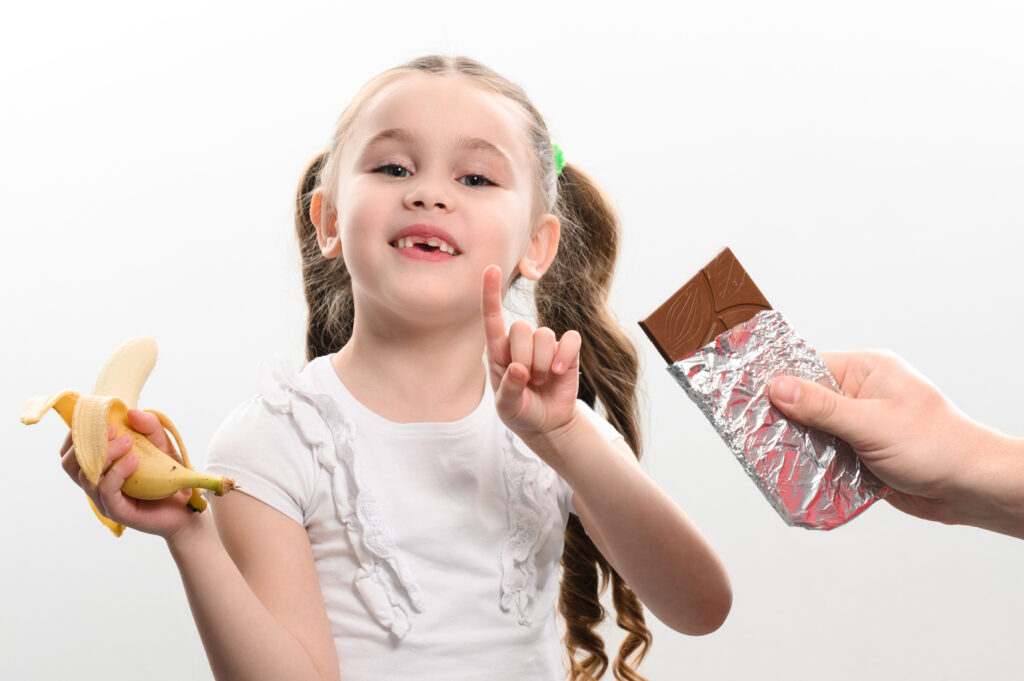 バナナを手にもちチョコレートを食べようとする女の子