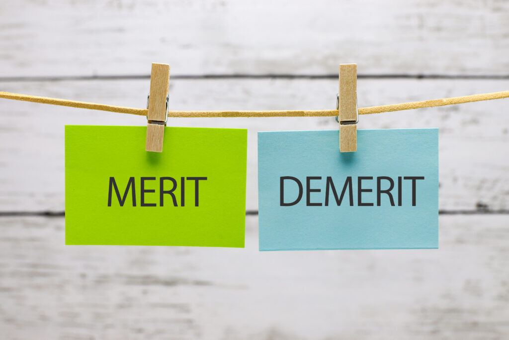 吊るされた緑のMERITのメモと青のDEMERITのメモ