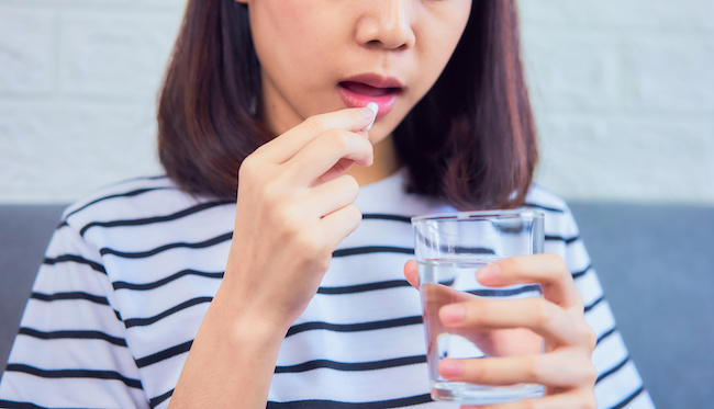 舌痛症で薬を飲む女性