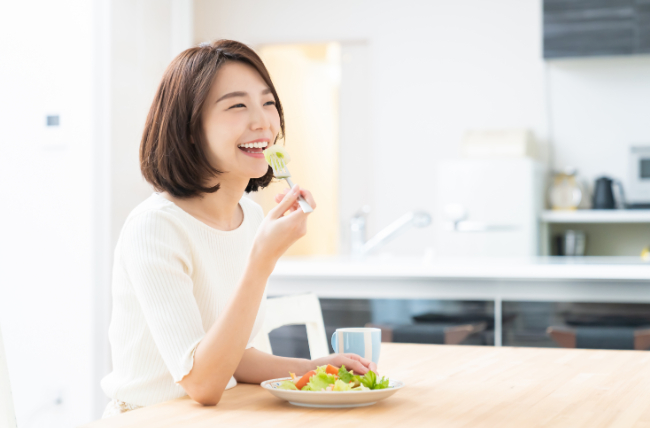 前歯の虫歯を治療し美味しく食事する女性